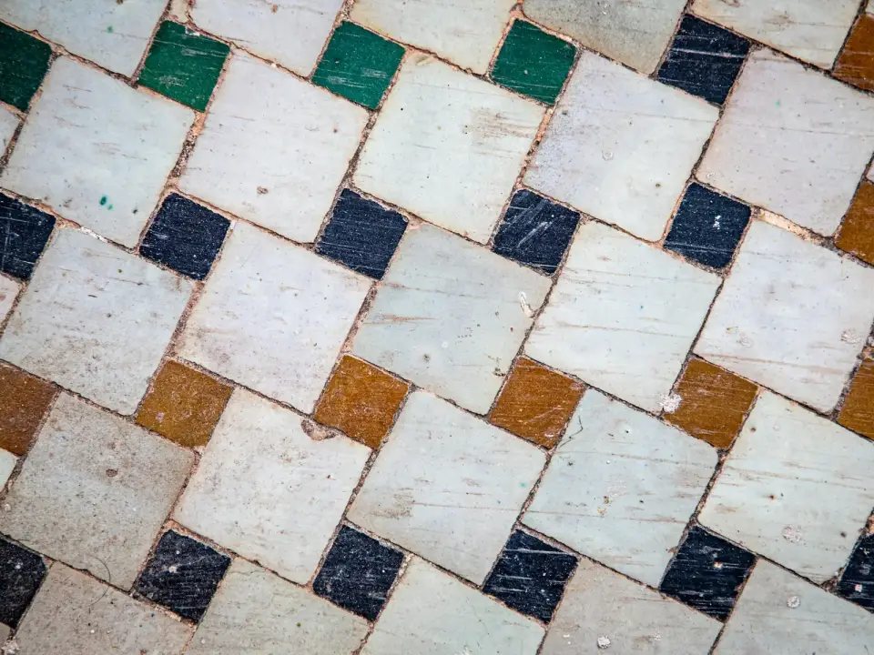 Carreaux carrés patinés posés en diagonale sur un sol ancien