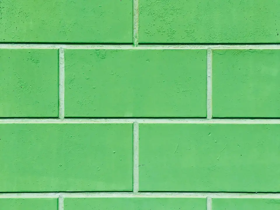Mur de carreaux émaillés vert clair aux joints blancs réguliers