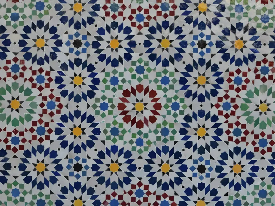 Mosaïque de zellige taillé à la main : étoiles et rosaces géométriques en vert, bleu, jaune et blanc