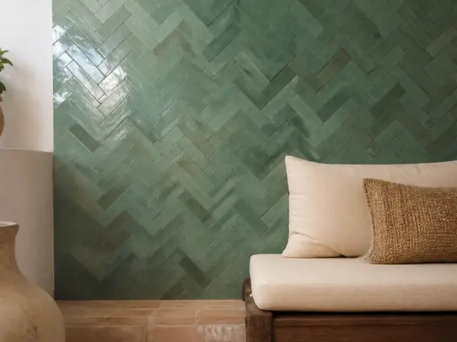 Carreaux rectangulaires de zellige vert d’eau posés en bâton rompu sur un mur, axe vertical bien visible